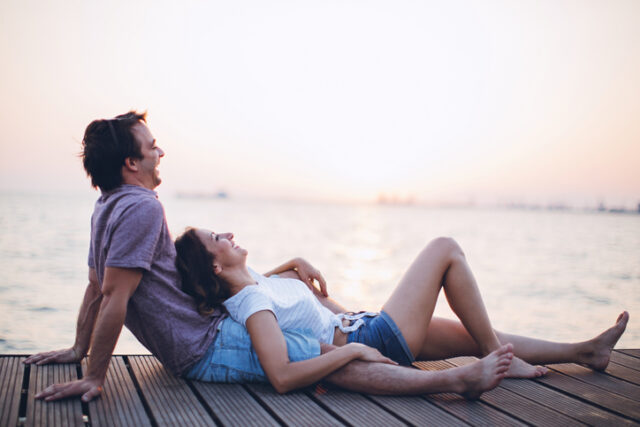 couple lounging on sunset pier