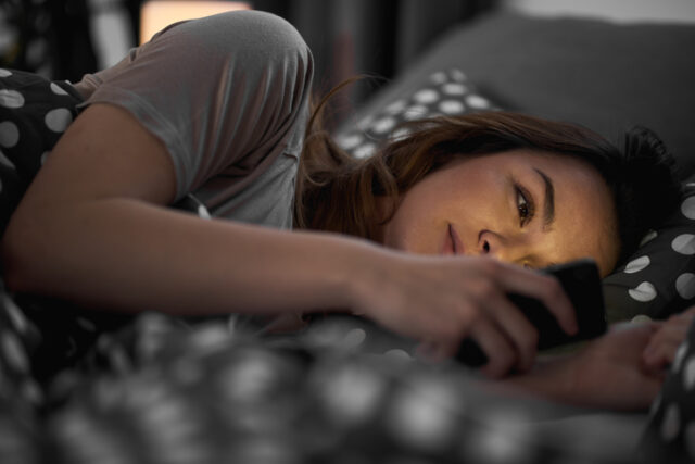 woman texting in bed at night