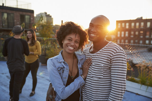 happy couple posing on sunset rooftop